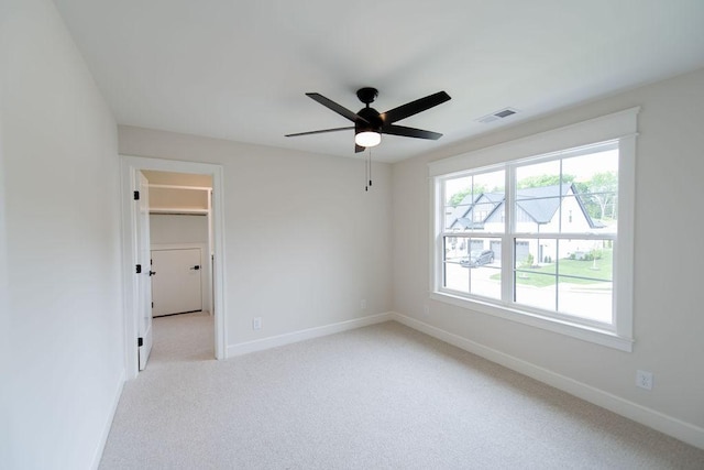 spare room featuring baseboards, carpet, a ceiling fan, and visible vents