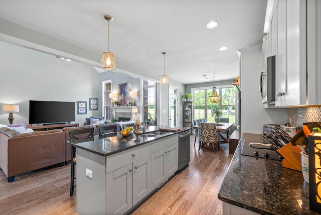 1005 Felts Dr, Clarksville, TN 37043 - kitchen with a fireplace, a sink, white cabinets, stainless steel appliances, and light wood-style flooring