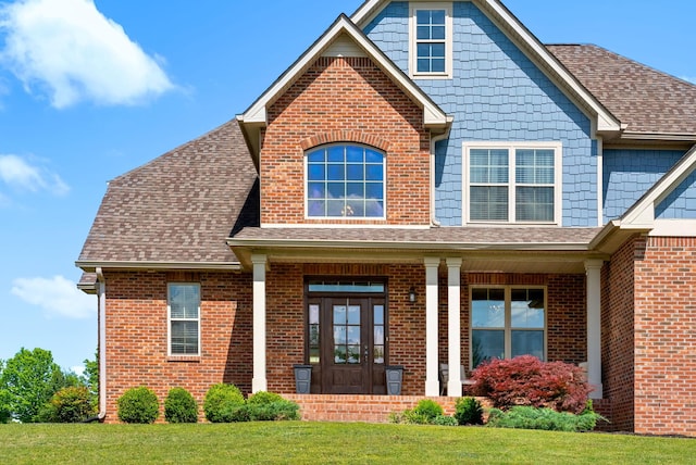 1005 Felts Dr, Clarksville, TN 37043 - view of front of house with covered porch, a shingled roof, a front lawn, and brick siding