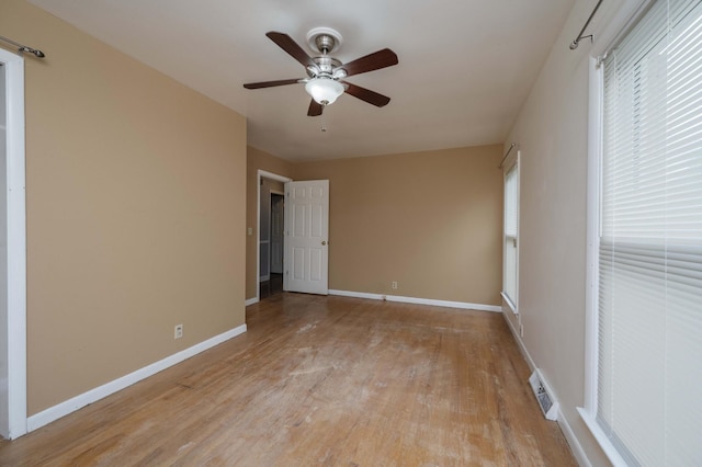 spare room with a ceiling fan, baseboards, visible vents, and light wood-type flooring