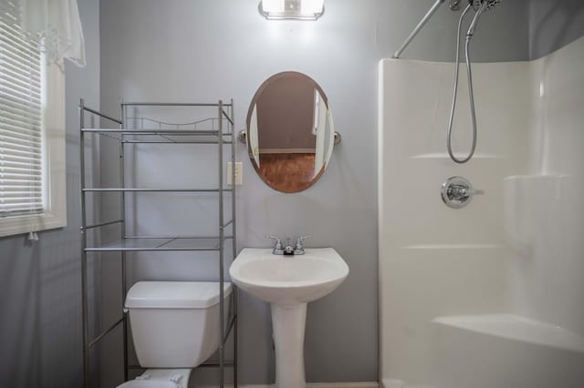 bathroom with a walk in shower and toilet