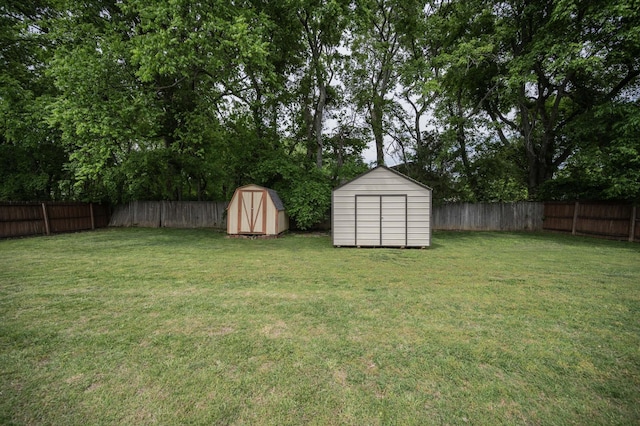 view of yard featuring a storage unit, a fenced backyard, and an outdoor structure