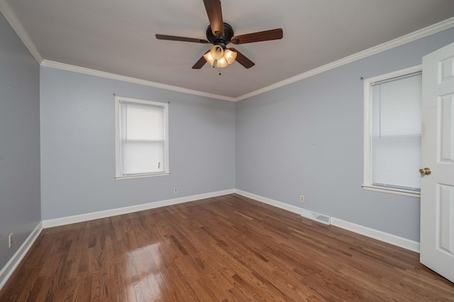 unfurnished room with visible vents, ornamental molding, baseboards, and wood finished floors