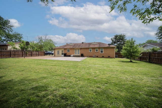 back of property with a lawn, crawl space, a fenced backyard, and a patio area
