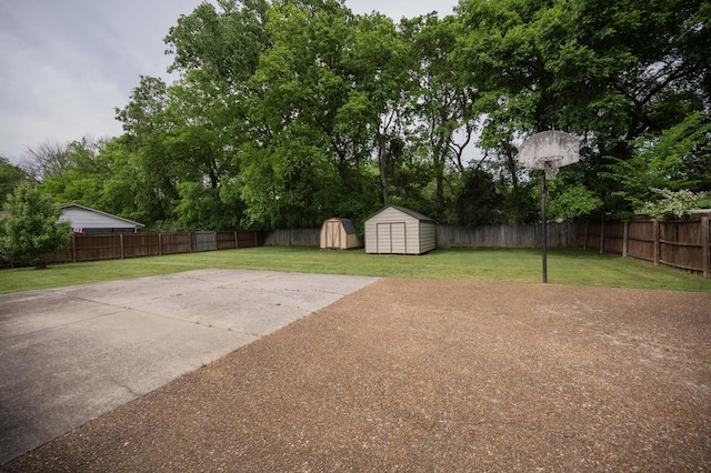 view of yard with a fenced backyard, a storage unit, an outbuilding, and a patio area
