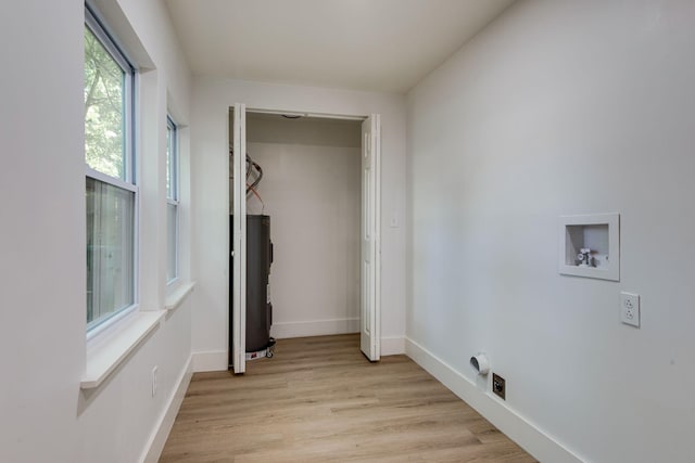washroom with washer hookup, baseboards, laundry area, and light wood finished floors