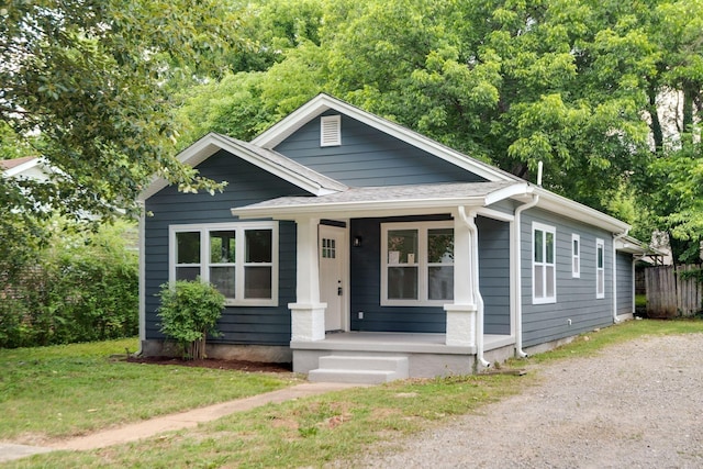 bungalow featuring covered porch and a front lawn