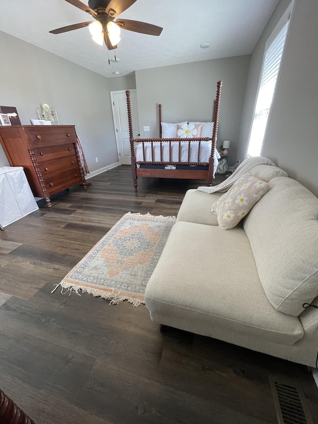 bedroom with baseboards, ceiling fan, wood finished floors, and visible vents