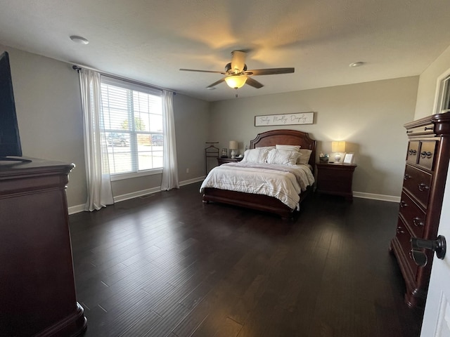 bedroom with baseboards, ceiling fan, and dark wood-type flooring