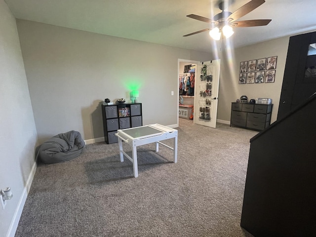 interior space featuring a ceiling fan, carpet floors, baseboards, a closet, and a spacious closet