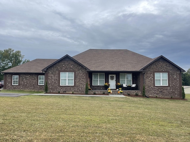 ranch-style house featuring brick siding, a shingled roof, and a front lawn