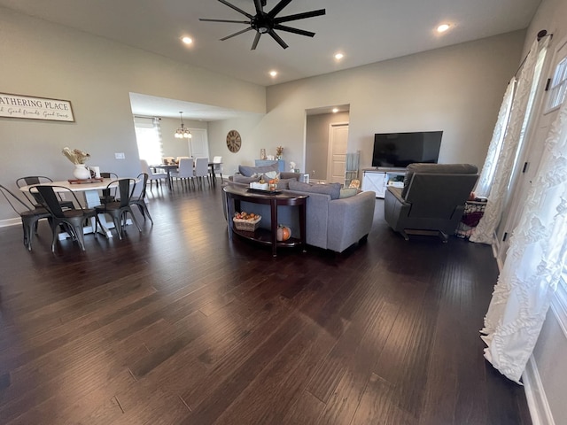 living room featuring recessed lighting, ceiling fan with notable chandelier, and dark wood-style floors