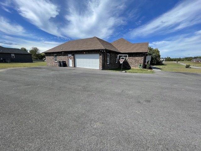 view of front of home with a garage, driveway, and brick siding