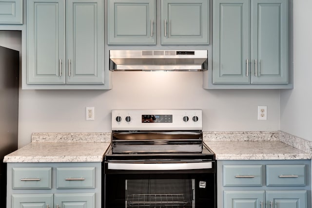 kitchen with under cabinet range hood, stainless steel appliances, and light countertops