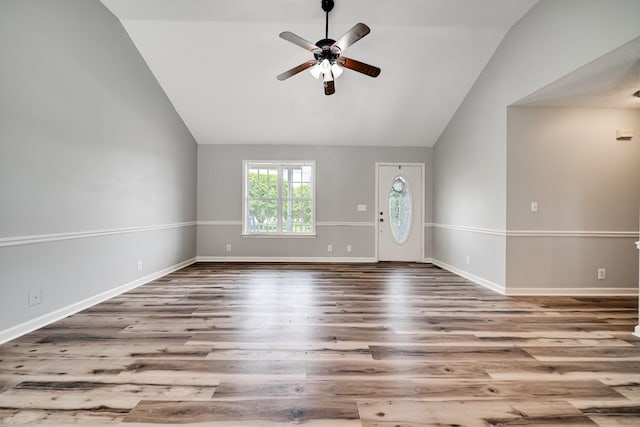 unfurnished living room with wood finished floors, baseboards, ceiling fan, and lofted ceiling