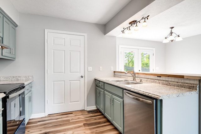 kitchen featuring black range with electric cooktop, light countertops, a sink, light wood finished floors, and dishwasher