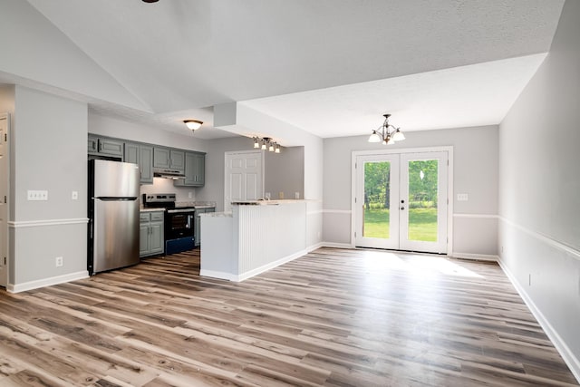 kitchen with stainless steel appliances, a chandelier, wood finished floors, and a peninsula