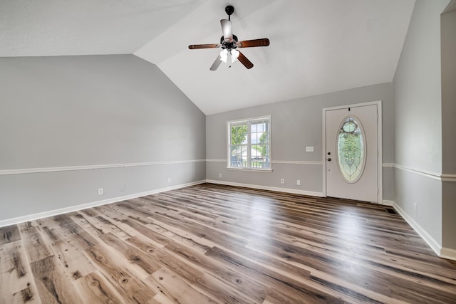 interior space with baseboards, ceiling fan, vaulted ceiling, and wood finished floors