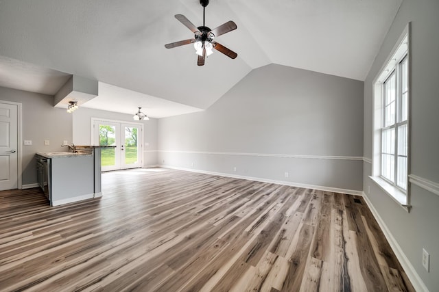 unfurnished living room featuring wood finished floors, baseboards, french doors, a ceiling fan, and vaulted ceiling