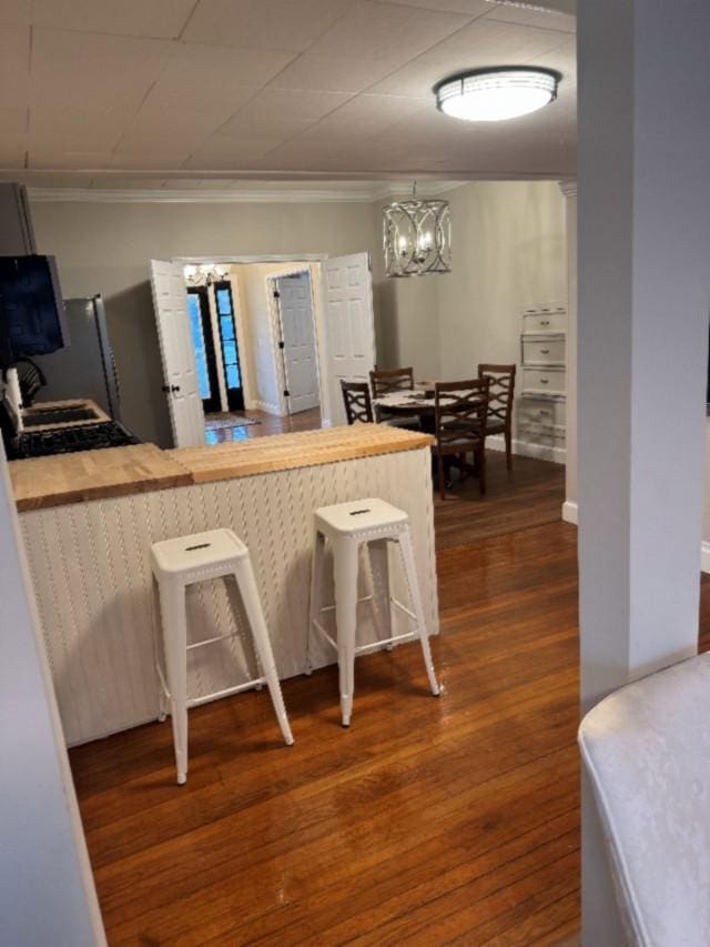 500 Brown St, Celina, TN 38551 - kitchen with a chandelier, crown molding, dark wood-type flooring, a kitchen bar, and a peninsula