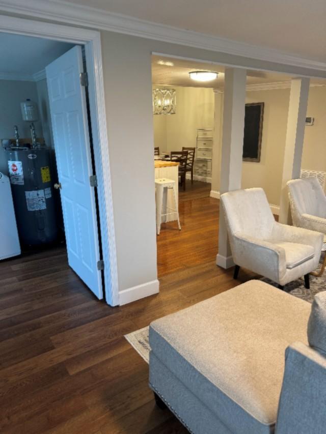 500 Brown St, Celina, TN 38551 - sitting room with electric water heater, ornamental molding, dark wood-style floors, baseboards, and a chandelier