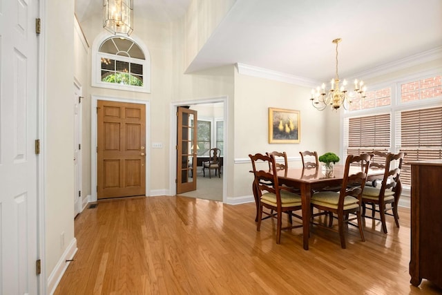 foyer with a notable chandelier, a wealth of natural light, and light wood-type flooring