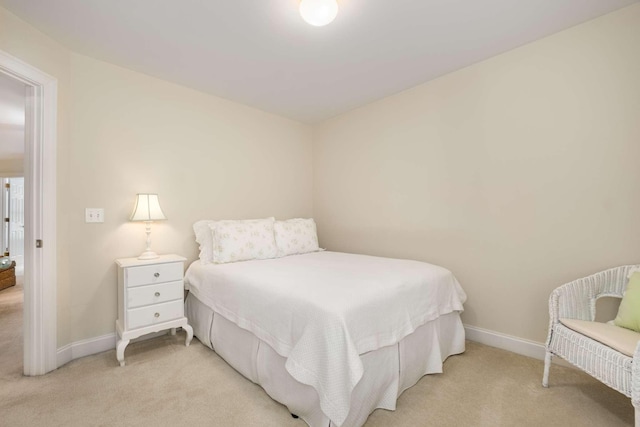 bedroom with baseboards and light colored carpet