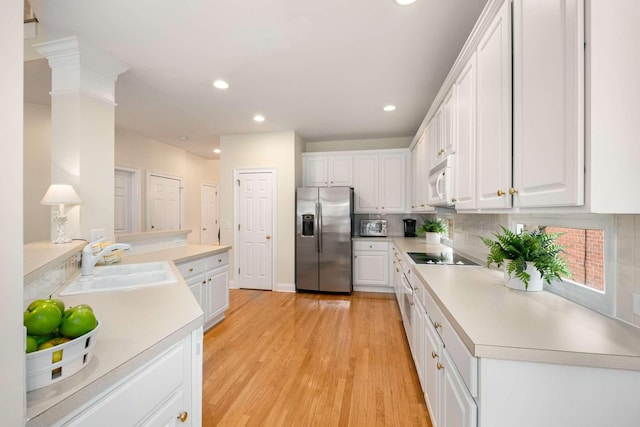 kitchen with recessed lighting, a sink, white cabinetry, and stainless steel appliances