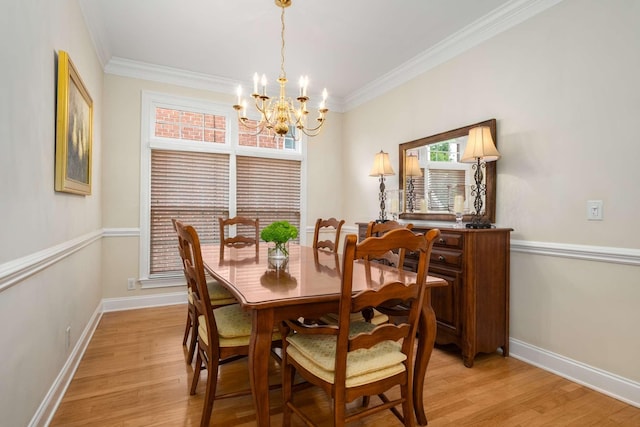 dining room with crown molding, baseboards, light wood-style floors, and a chandelier