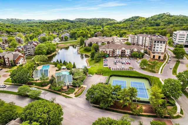 drone / aerial view featuring a water view and a wooded view