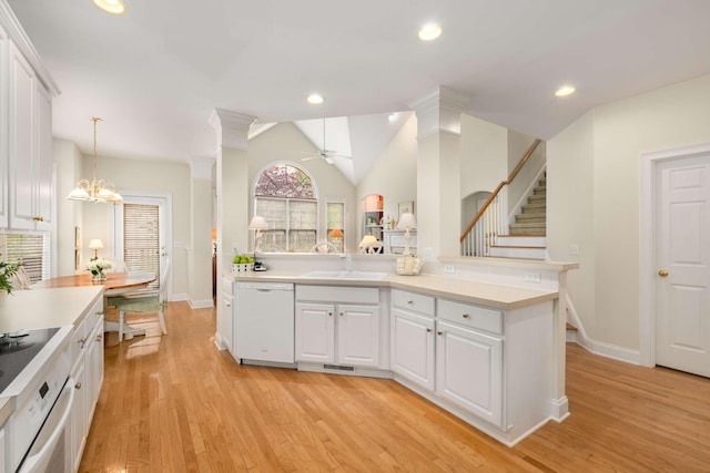 kitchen with oven, baseboards, white cabinets, a sink, and dishwasher
