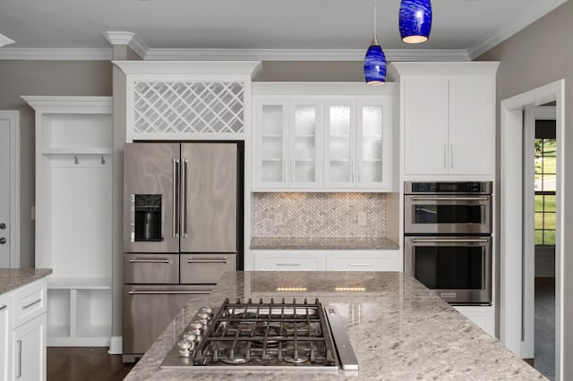 kitchen featuring glass insert cabinets, white cabinetry, tasteful backsplash, light stone counters, and appliances with stainless steel finishes