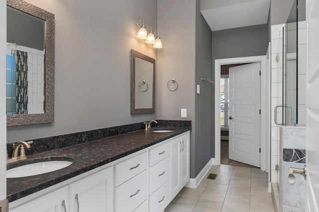 full bathroom with double vanity, tile patterned floors, a sink, and a stall shower