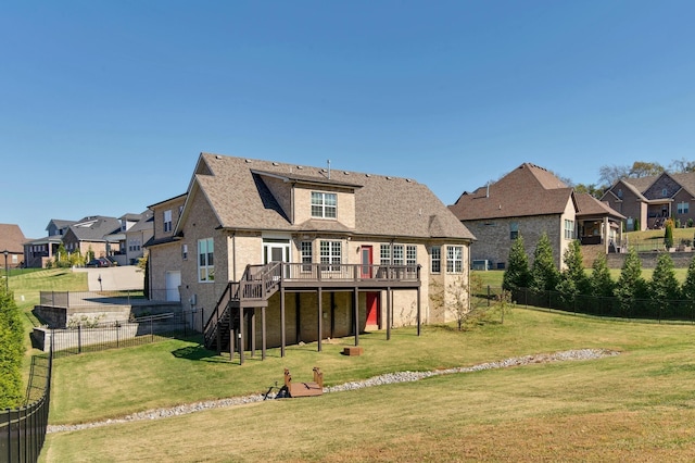 rear view of property featuring a residential view, a yard, and a deck