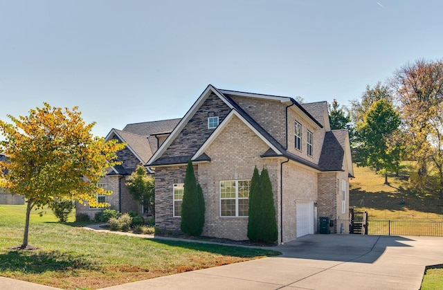 view of front of property featuring brick siding, a front lawn, fence, and concrete driveway