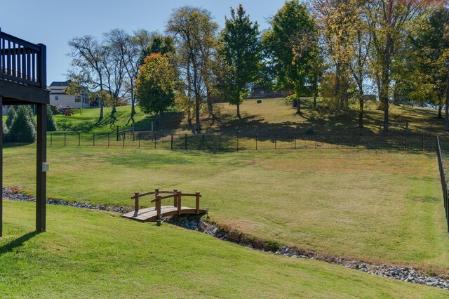 view of community featuring a lawn and fence