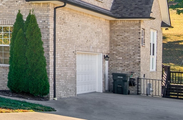 view of home's exterior with fence, an attached garage, concrete driveway, and a shingled roof