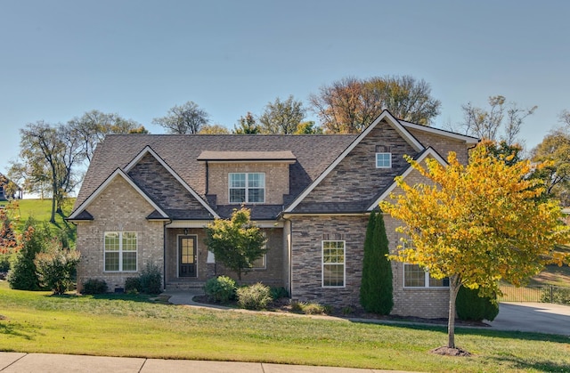 craftsman inspired home featuring a front lawn and brick siding