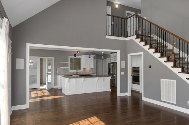 unfurnished living room featuring a sink, high vaulted ceiling, dark wood-style flooring, and visible vents