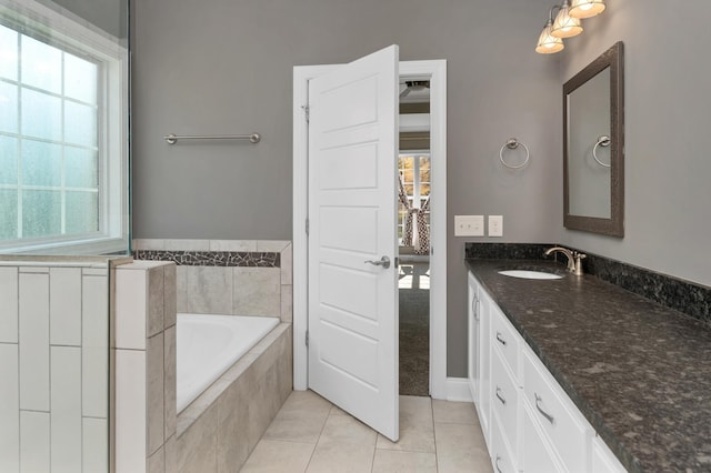 bathroom with tile patterned flooring, a bath, and vanity