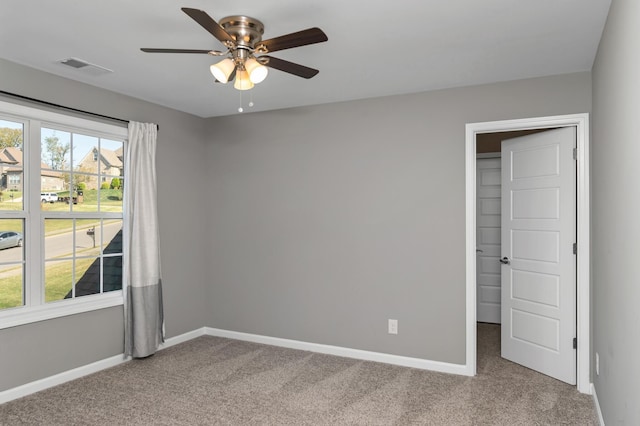 spare room featuring baseboards, ceiling fan, and carpet