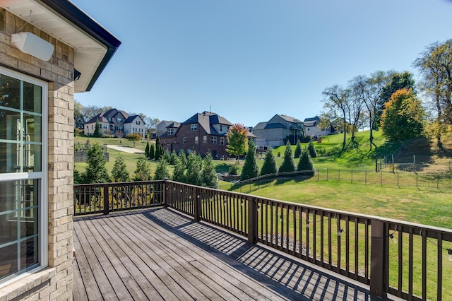 wooden deck featuring a lawn, a fenced backyard, and a residential view