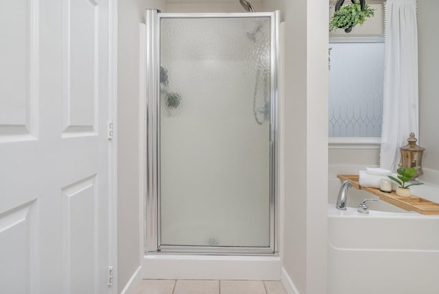 bathroom featuring baseboards, tile patterned flooring, a shower stall, and a bath