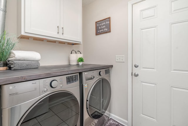 washroom with baseboards, cabinet space, and independent washer and dryer