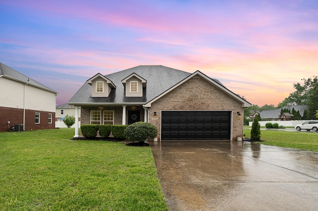 traditional-style house with a lawn, an attached garage, concrete driveway, and brick siding