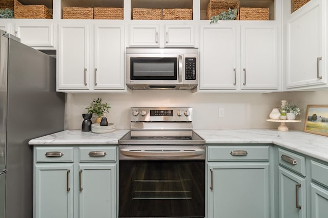 kitchen featuring white cabinetry, light stone countertops, and stainless steel appliances