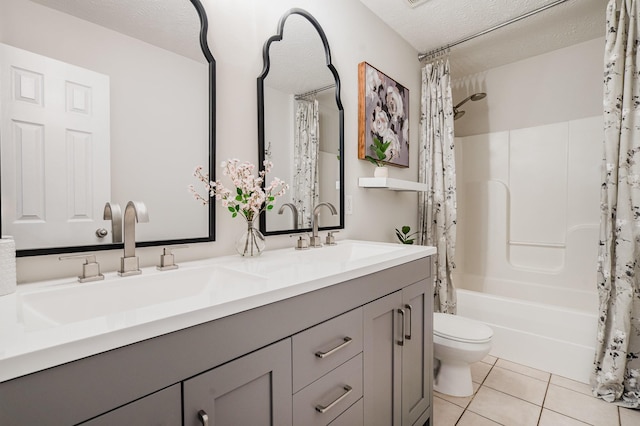 bathroom featuring double vanity, toilet, tile patterned floors, and a sink