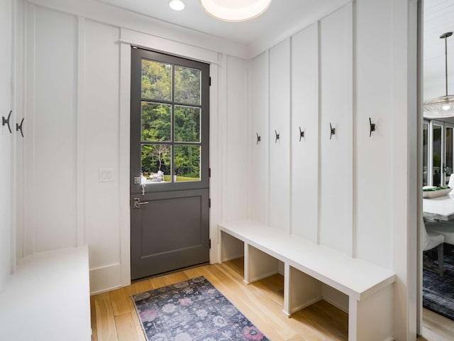mudroom featuring light wood-style floors and a decorative wall