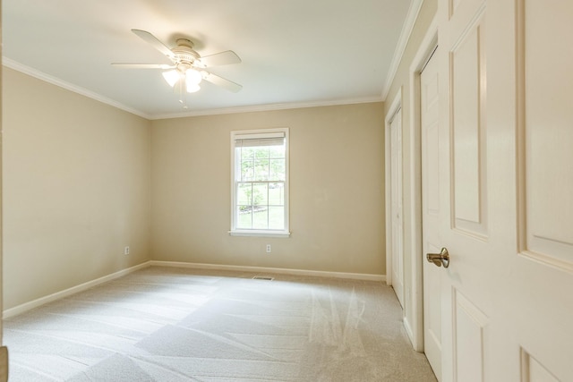 unfurnished bedroom with a ceiling fan, visible vents, baseboards, ornamental molding, and light carpet