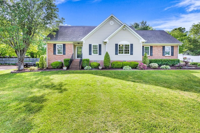 ranch-style house with brick siding, fence, and a front yard